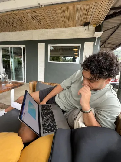 Djenthan working on a laptop on a terrace