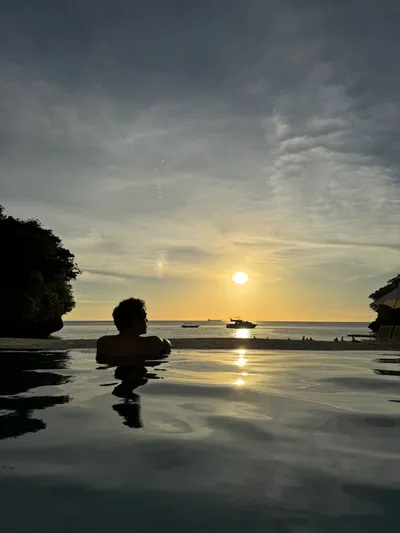 Djenthan in an infinity pool at sunset