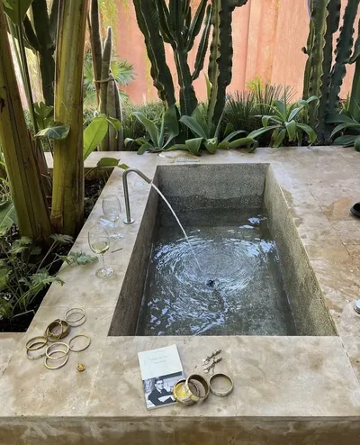 Outdoor stone bath surrounded by cacti