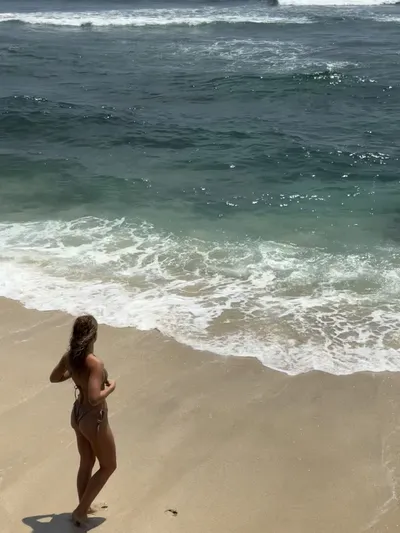 Lara walking along a tropical beach